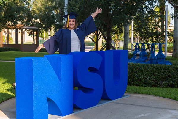 NSU Graduate standing in front of NSU